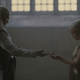 Daemon Targaryen hands his niece Rhaenyra a gift in the throne room.